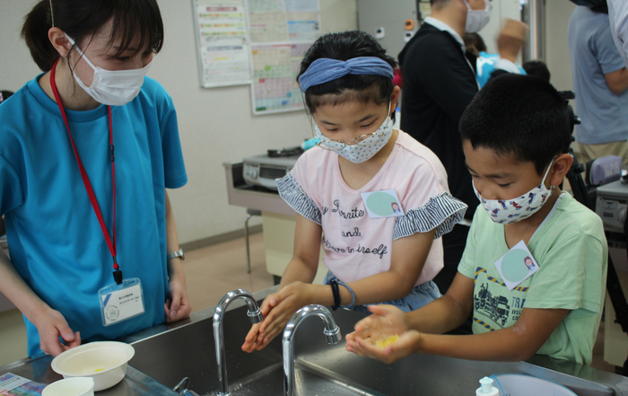 子どもたちに自分で作った石鹸を使って手洗い